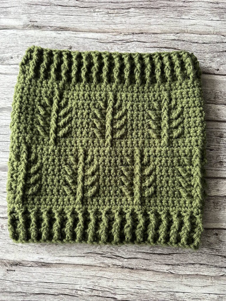 Evergreen Christmas textured crochet cowl with repeating pine branch motif and ribbed edges