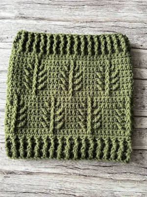 Evergreen Christmas textured crochet cowl with repeating pine branch motif and ribbed edges