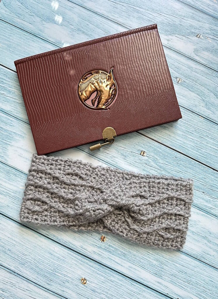 Cable weave crochet headband styled as a winter accessory, showing the textured cable pattern