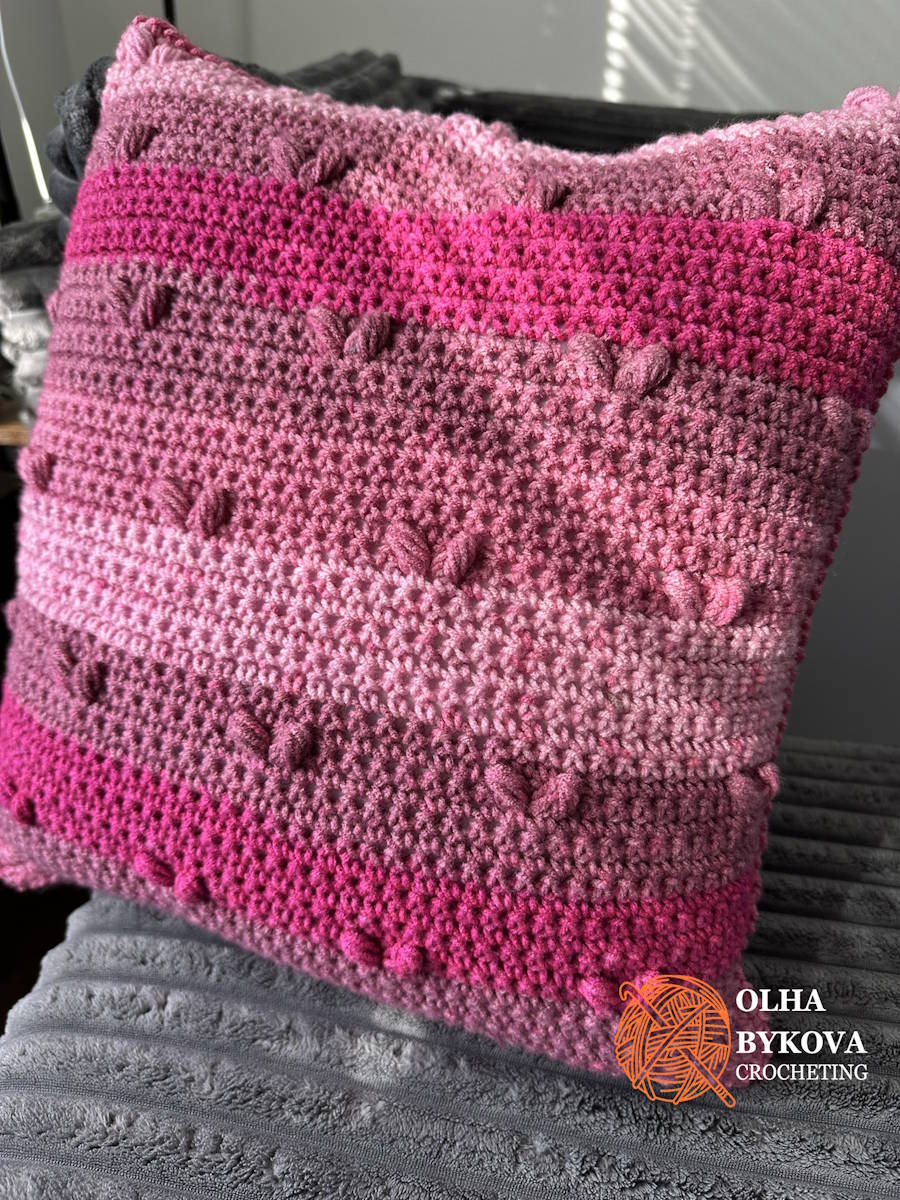Textured crochet pillow cover with heart pattern displayed on a sofa as Valentine’s Day home decor.