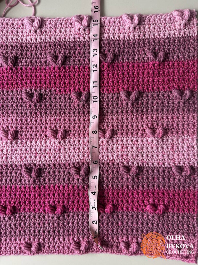 Front panel height measurement for a textured crochet pillow cover with heart stitches.