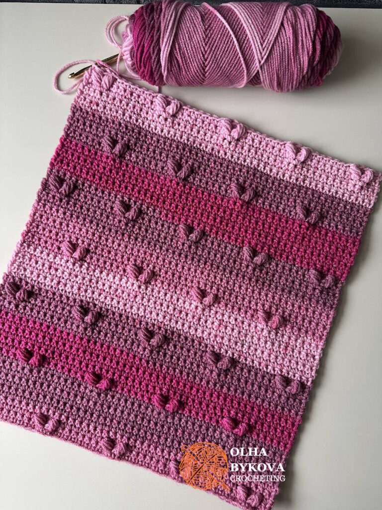 Simple Hearts Crochet Stitch textured crochet square with raised heart motifs, shown with yarn for scale