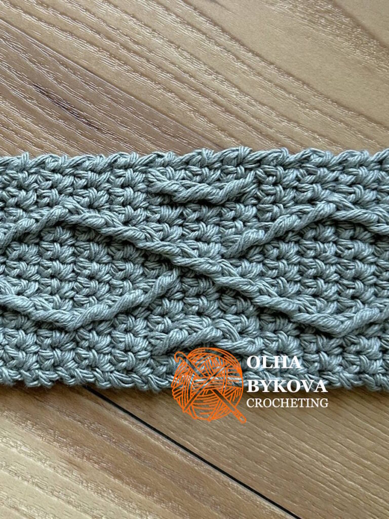Close-up of textured crochet diamond weave stitches, cup cozy pattern with cable-inspired aran texture