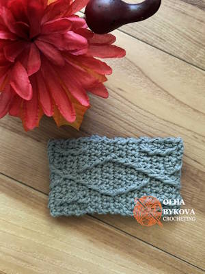 Textured crochet cup cozy Diamond Weave pattern, coffee sleeve design with woven stitch texture on wooden background. Preview