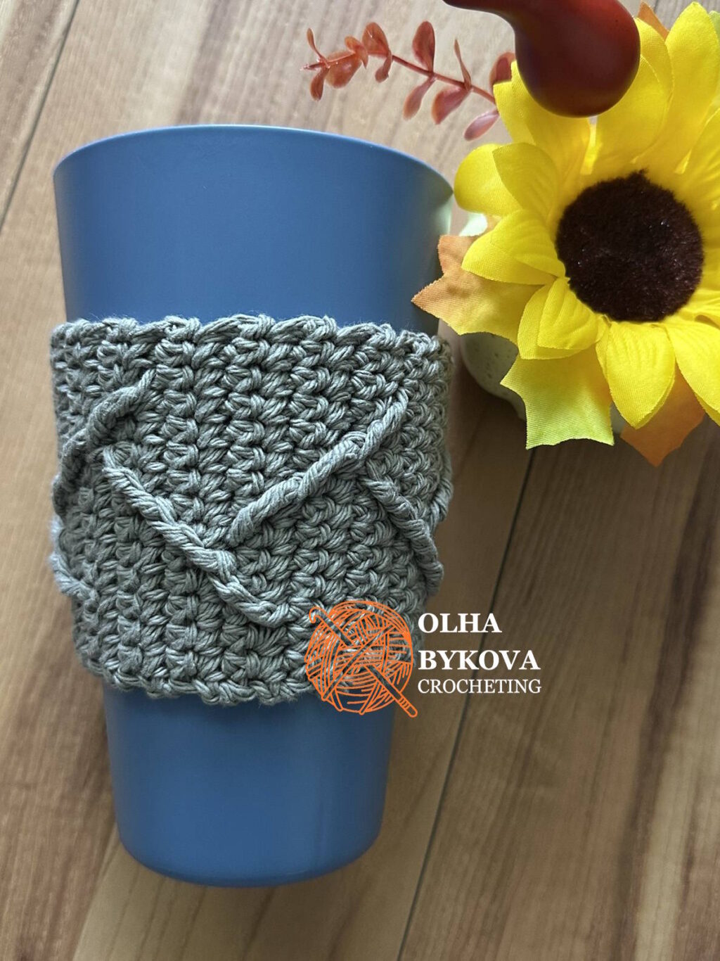 crochet cup cozy with textured cable pattern on reusable coffee cup