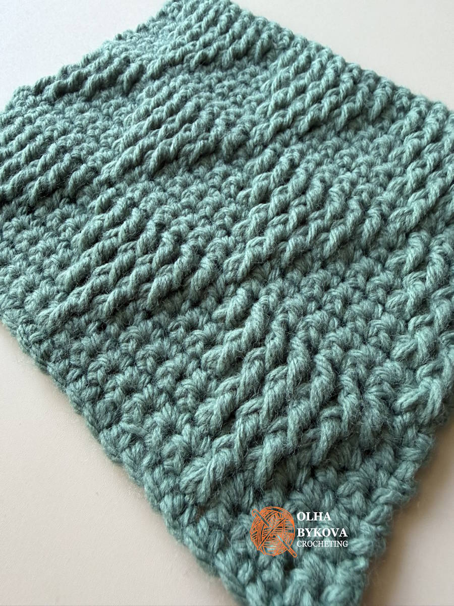 Angled view of a basket weave crochet stitch pattern featuring raised textured rows that create a woven triangle effect, suitable for blankets, scarves, and home décor projects.