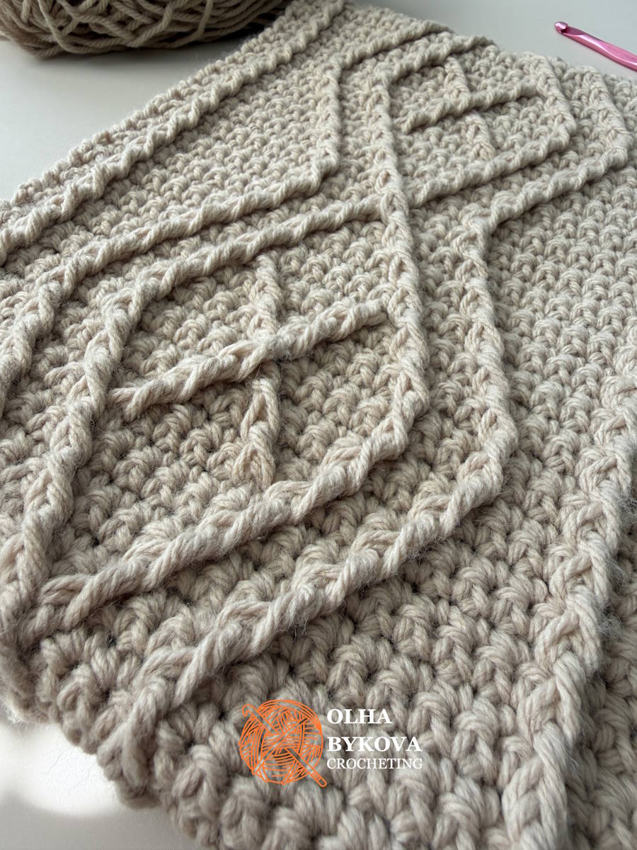 Close-up of the raised crochet cable stitches forming the geometric Diamond Frame design